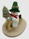 Schneemann auf Holzschlitten